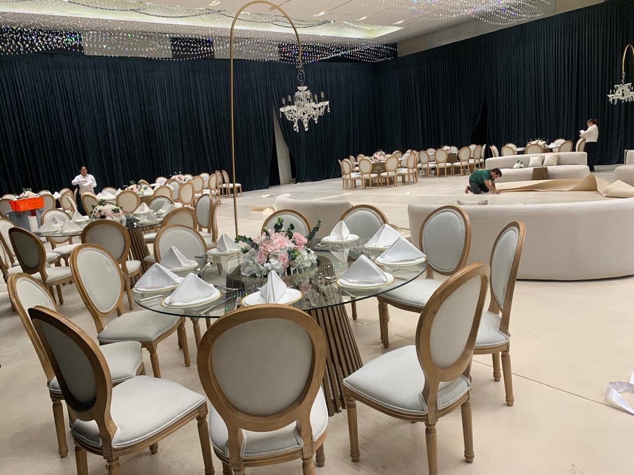 Glass table with wooden Louis chairs in a ballroom