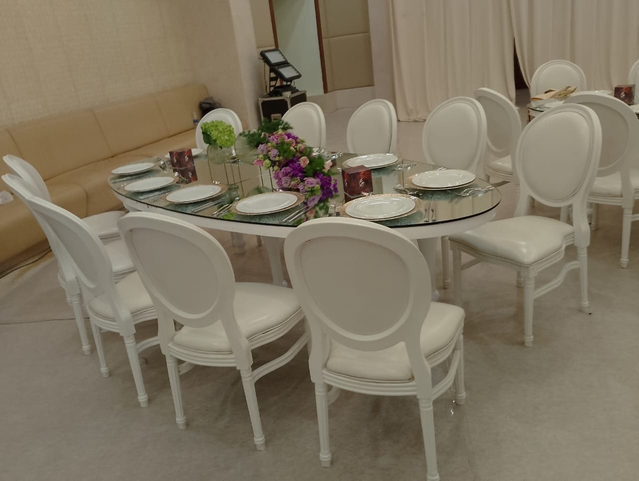 Oval mirror-top table with white Louis chairs
